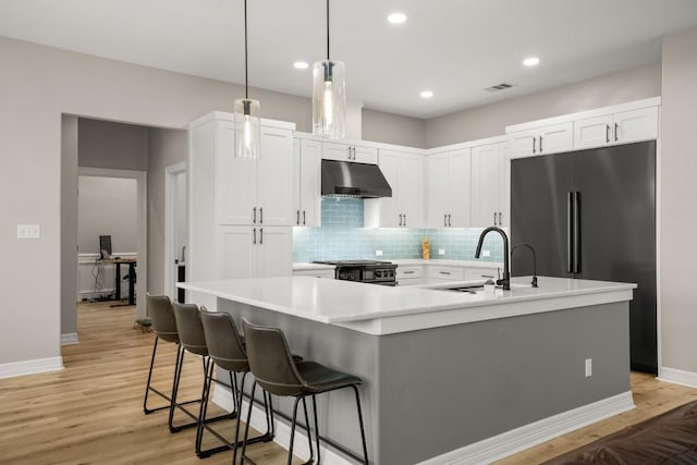 601 Scenic Path, Leander, TX 78641 - kitchen with under cabinet range hood, high quality fridge, range with gas cooktop, light countertops, and baseboards