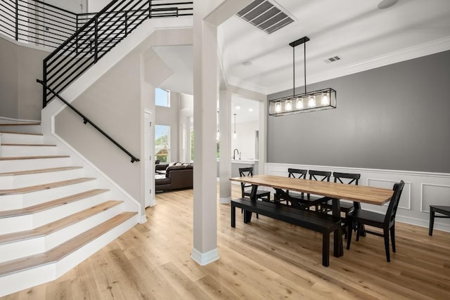 dining space with visible vents, wood finished floors, and stairway