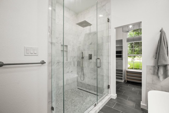 bathroom featuring a marble finish shower and tile patterned flooring
