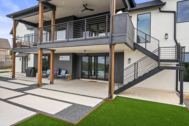 back of property with ceiling fan, a patio area, fence, a balcony, and stucco siding