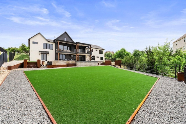 view of yard with fence and a balcony