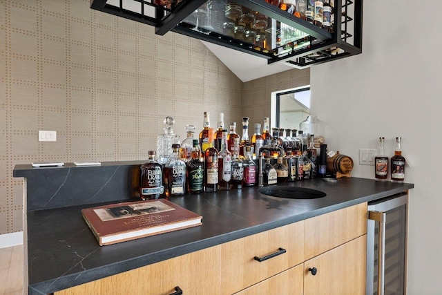 bar featuring wine cooler, indoor wet bar, and lofted ceiling