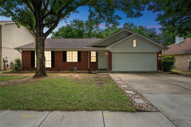 single story home featuring an attached garage, a yard, driveway, and brick siding