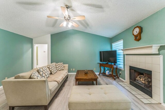 living room featuring wood finished floors, a ceiling fan, a textured ceiling, and lofted ceiling