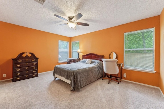 bedroom featuring visible vents, carpet flooring, a textured ceiling, and a ceiling fan