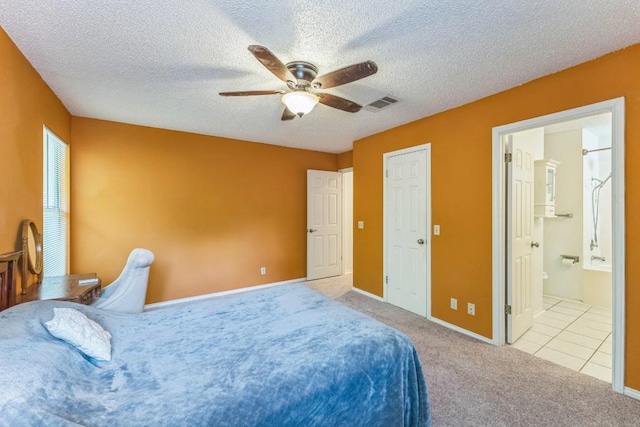 carpeted bedroom with visible vents, baseboards, a textured ceiling, connected bathroom, and a ceiling fan