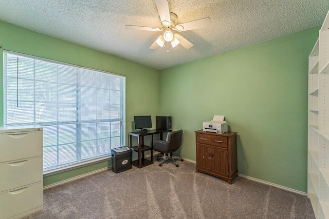 carpeted office featuring baseboards, a ceiling fan, and a textured ceiling
