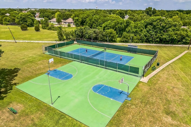 view of sport court featuring fence, community basketball court, a tennis court, and a yard