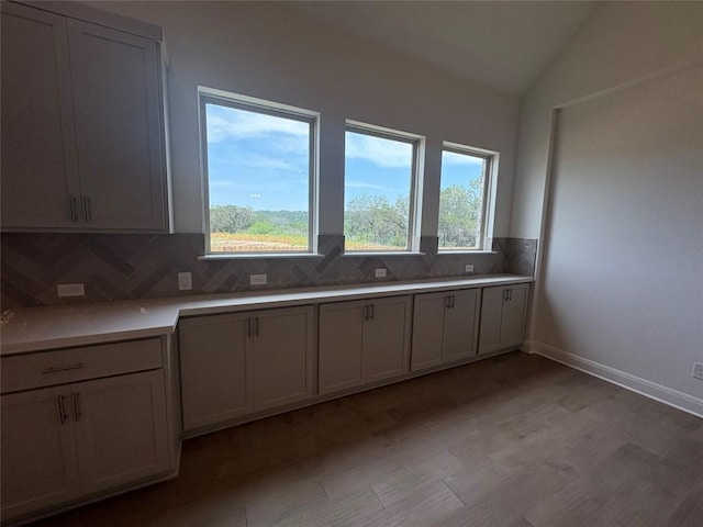 1728 Scenic Heights Ln, Georgetown, TX 78628 - kitchen featuring decorative backsplash, light wood-style floors, light countertops, vaulted ceiling, and baseboards