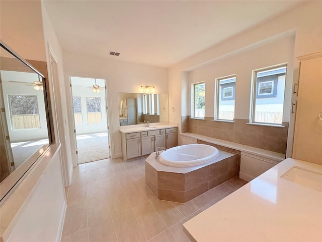 1728 Scenic Heights Ln, Georgetown, TX 78628 - full bath featuring two vanities, a garden tub, tile patterned flooring, and ceiling fan