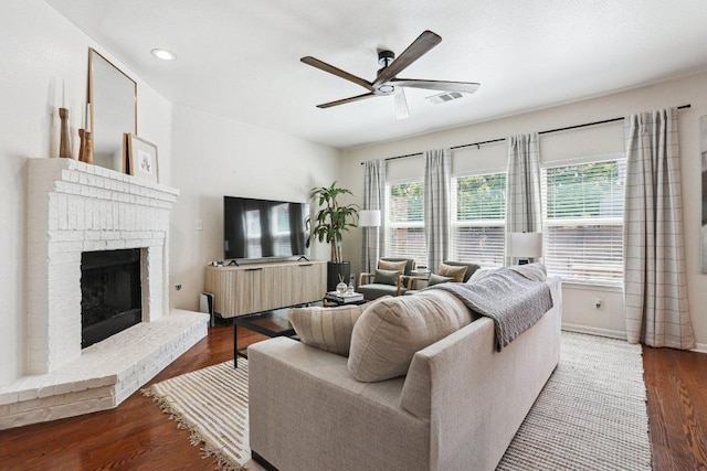 living room with a ceiling fan, a fireplace, wood finished floors, baseboards, and recessed lighting