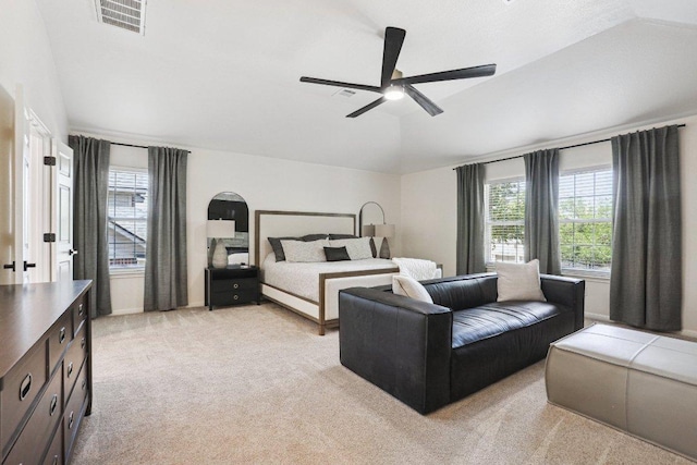 bedroom with ceiling fan, light carpet, vaulted ceiling, and visible vents