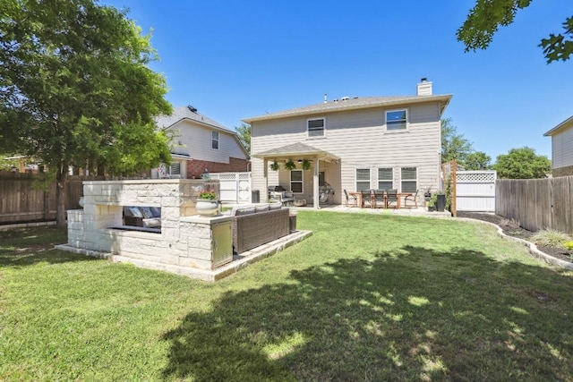 rear view of property with a yard, a chimney, a fenced backyard, and a patio area