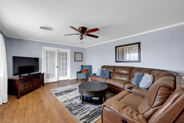 1309 E Brown St, Llano, TX 78643 - living area with wood finished floors, a ceiling fan, crown molding, and french doors