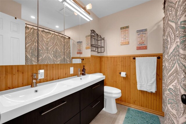 1309 E Brown St, Llano, TX 78643 - full bathroom with wood walls, double vanity, a shower with shower curtain, a wainscoted wall, and tile patterned flooring
