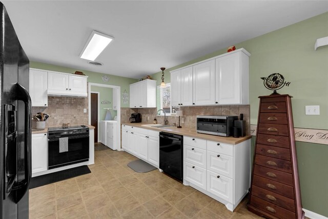 1309 E Brown St, Llano, TX 78643 - kitchen featuring black appliances, separate washer and dryer, light countertops, white cabinetry, and tasteful backsplash