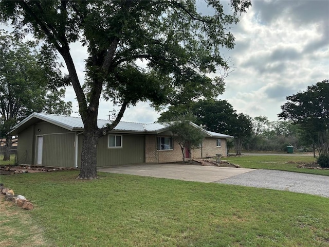 1309 E Brown St, Llano, TX 78643 - view of front of home featuring driveway, a front yard, and a metal roof
