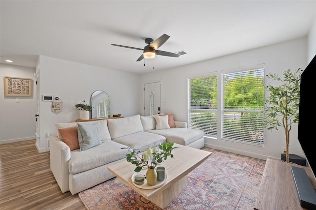 living area with baseboards, ceiling fan, wood finished floors, and visible vents