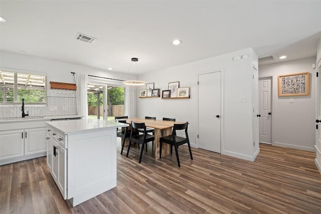 kitchen with open shelves, a sink, light countertops, tasteful backsplash, and visible vents