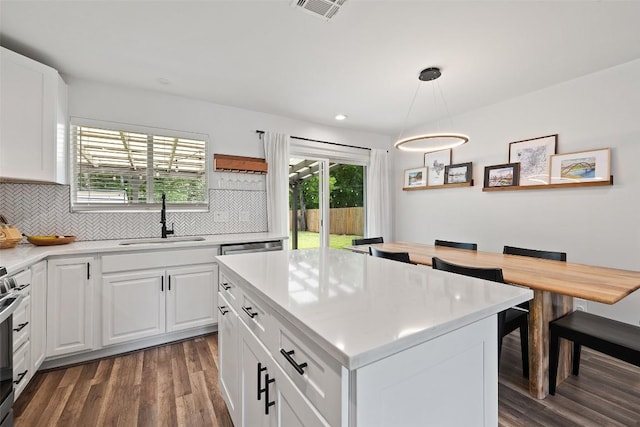 kitchen featuring decorative backsplash, a sink, light countertops, dark wood-style floors, and white cabinetry