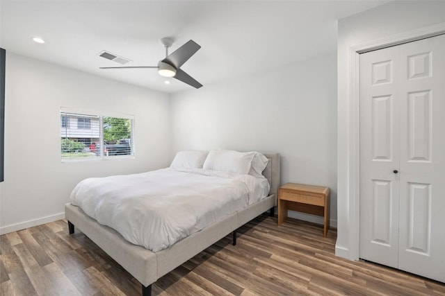 bedroom with a ceiling fan, visible vents, wood finished floors, baseboards, and recessed lighting