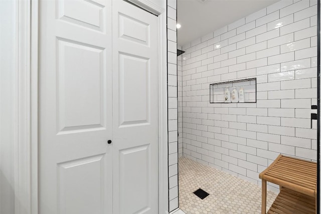 bathroom with a closet, a tile shower, and recessed lighting