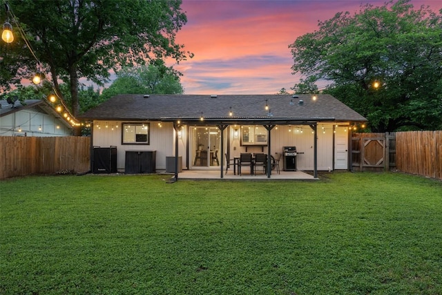 back of house with a fenced backyard, a gate, a yard, and a patio area