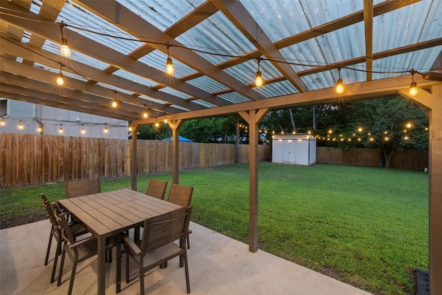 view of patio / terrace featuring a pergola, a storage shed, a fenced backyard, an outbuilding, and outdoor dining area