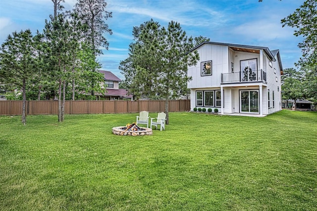 141 Awehi Ln, Bastrop, TX 78602 - back of house with a balcony, a fire pit, and board and batten siding