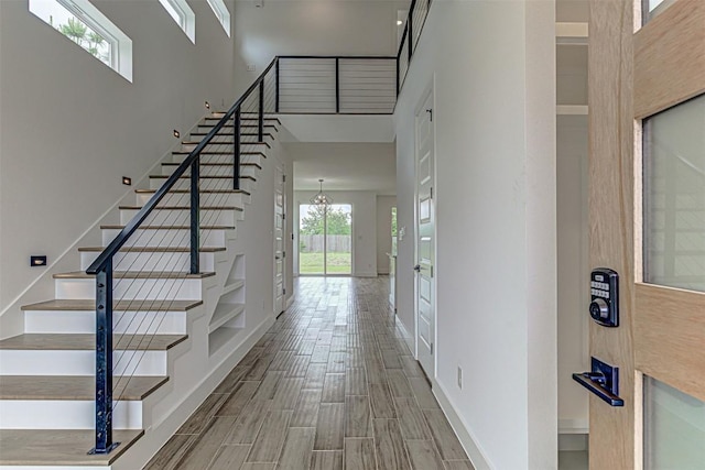 141 Awehi Ln, Bastrop, TX 78602 - stairs with a towering ceiling, wood tiled floors, baseboards, and a chandelier