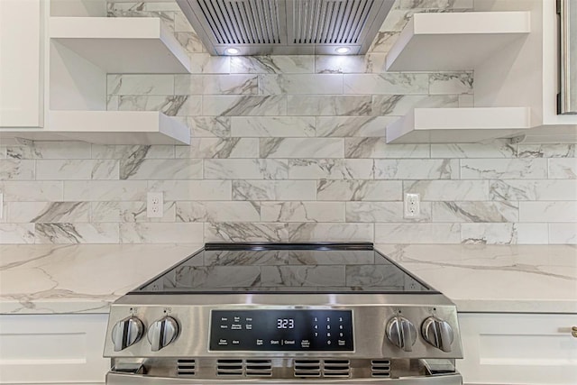 141 Awehi Ln, Bastrop, TX 78602 - kitchen with stainless steel range with electric stovetop, open shelves, exhaust hood, and white cabinets