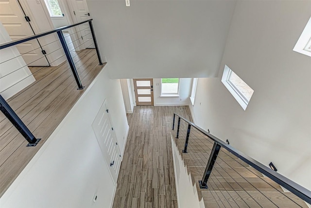141 Awehi Ln, Bastrop, TX 78602 - staircase featuring a skylight, wood finished floors, a towering ceiling, and baseboards