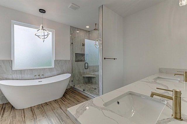 141 Awehi Ln, Bastrop, TX 78602 - bathroom with a shower stall, a freestanding bath, double vanity, and tile walls