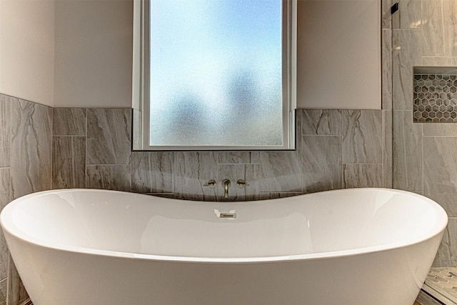 141 Awehi Ln, Bastrop, TX 78602 - bathroom featuring a freestanding bath and tile walls