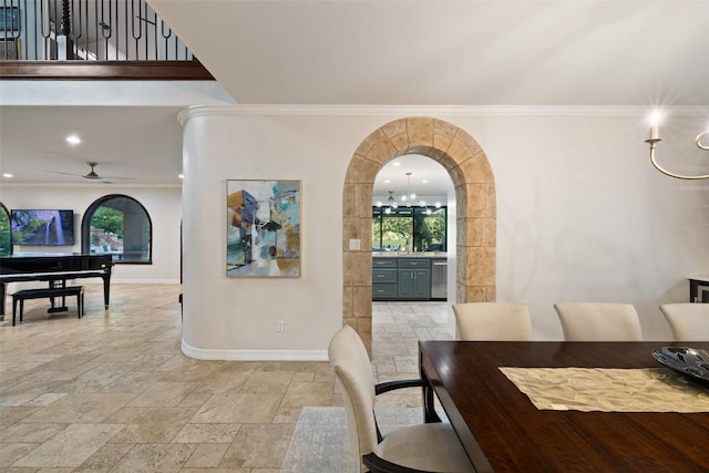 dining area featuring crown molding, baseboards, and stone tile flooring