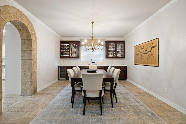 dining area with baseboards, stone tile floors, arched walkways, and ornamental molding