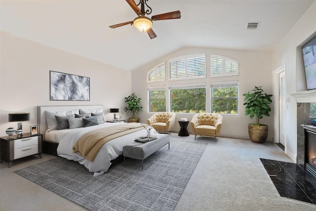 carpeted bedroom featuring a premium fireplace, ceiling fan, visible vents, and lofted ceiling