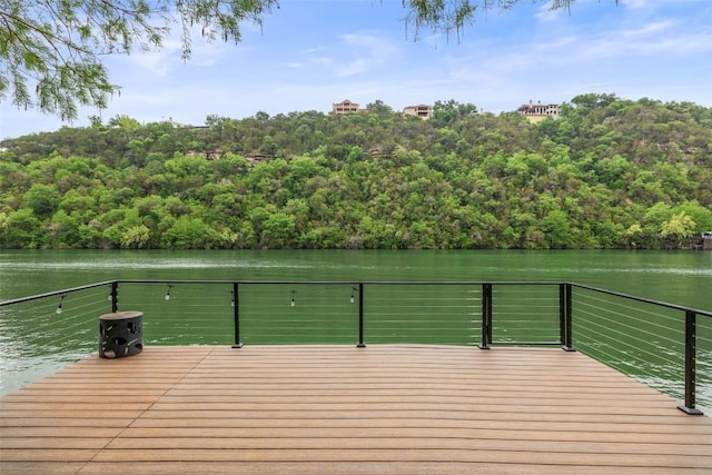 dock area with a view of trees and a deck with water view