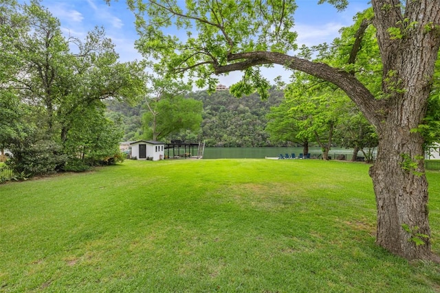 view of yard featuring a water view and a forest view