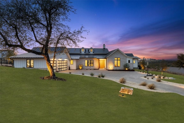 exterior space with a standing seam roof, a front lawn, driveway, and metal roof