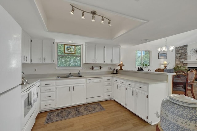 1871 Patty Dr, Canyon Lake, TX 78133 - kitchen featuring white appliances, a tray ceiling, light wood-type flooring, and white cabinets
