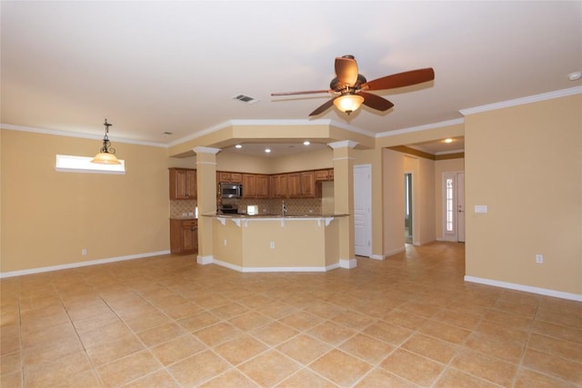 unfurnished living room featuring crown molding, baseboards, a ceiling fan, and ornate columns