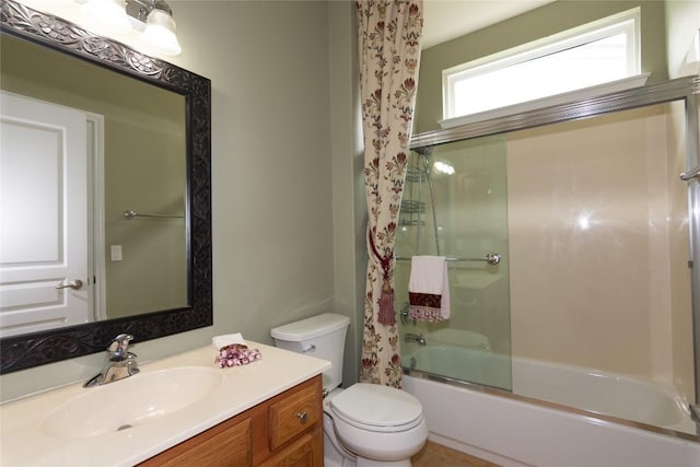 bathroom with toilet, bath / shower combo with glass door, and vanity