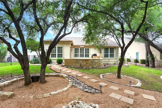 ranch-style house with fence, stucco siding, and a front yard