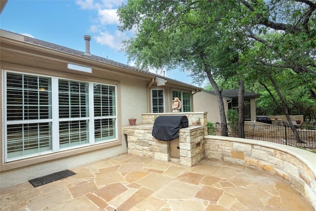 view of patio with fence, grilling area, and an outdoor kitchen
