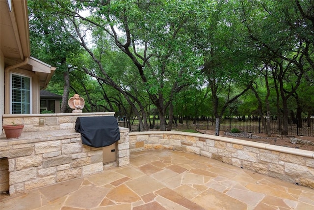 view of patio / terrace featuring fence, grilling area, and exterior kitchen
