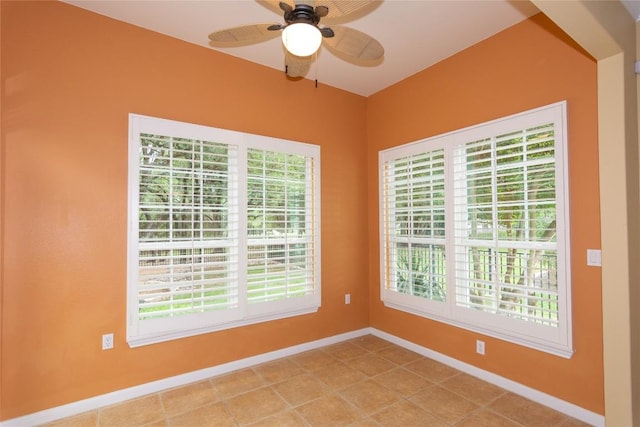 empty room featuring light tile patterned floors, baseboards, and ceiling fan