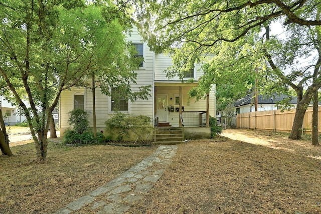 view of front of property featuring fence and a porch