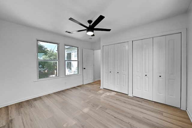 unfurnished bedroom featuring baseboards, visible vents, ceiling fan, and light wood-style floors