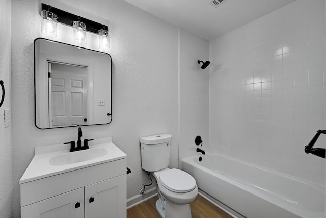 bathroom with shower / bath combination, wood finished floors, vanity, baseboards, and toilet